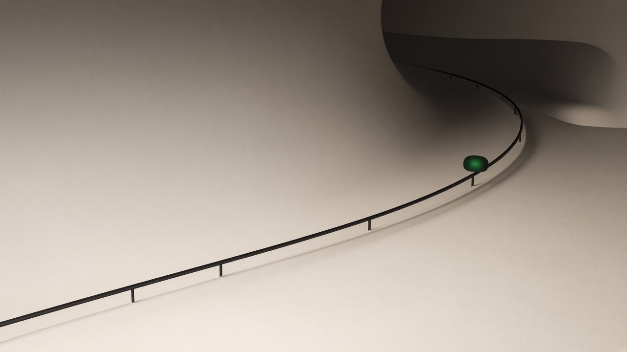 A pale curved track with a thin black rail and a single green light.